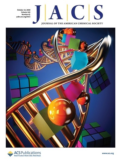 The image depicts the cover of the JACS issue. The cover shows a double helix of DNA twisting into the background, interspaced with material superlattices.
